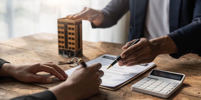 Real estate agent talked about the terms of the home purchase agreement and asked the customer to sign the documents to make the contract legally, Home sales and home insurance concept...
