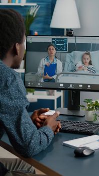 Worried dad for her little girl in hospital ward, talking with doctor on video conference call using webcam app remote screen for family connection. Family doctor consultation via internet