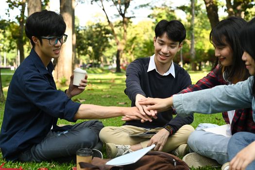 Group of friends, university students stacking hands together. University, youth lifestyle and friendship concept.