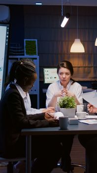 Businesswoman leder sitting at conference table discussing with business teamwork planning company management presentation. Diverse multi ethnic coworkers brainstorming ideas in meeting room