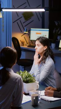 Workaholics diverse multi-ethnic teamwork having online videocall conference meeting overworking at financial strategy in office room late at night. Focused teamwork discussing company ideas in evening