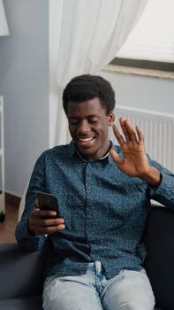 African american guy greeting colleagues or family while talking on online video conference call. Working from home remote worker in distance communication chat, learning and connecting