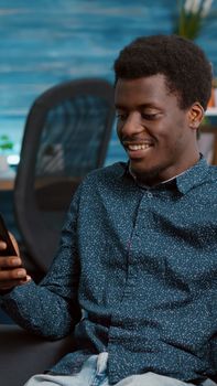 Authentic african american man on virtual communication video call using his phone to talk with relatives or work colleagues. Black freelancer on internet online video conference call