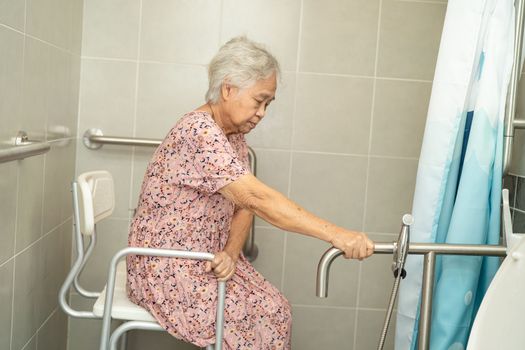 Asian elderly woman patient use toilet bathroom handle security in nursing hospital ward, healthy strong medical concept.