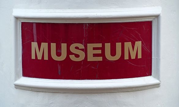 Museum written in golden letters on dark red background. Seen on the wall of a museum in Hardenberg, the Netherlands