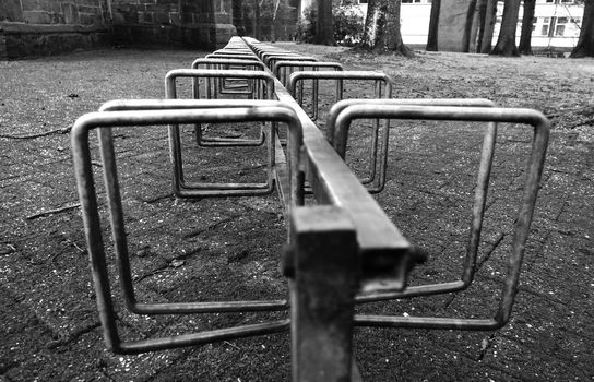 Row of bicycle stands at a church in black and white. Location: Emlichheim, Germany