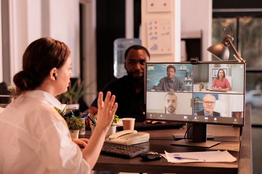 Woman discussing startup strategy with colleagues on videocall meeting, chatting with remote employees on teleconference. Business plan discussion, diverse coworkers online communication