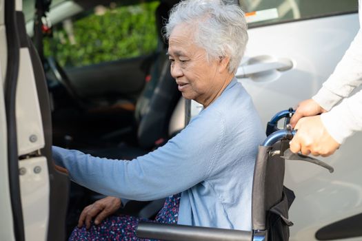 Asian senior or elderly old lady woman patient sitting on wheelchair prepare get to her car, healthy strong medical concept.