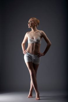 young sexy gymnast girl walk in training cloth look at light