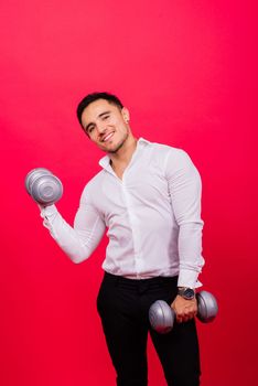 Business man with fitness dumbbells wear shirt. Studio shoot on red background