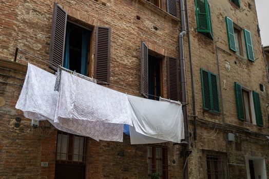 Laundry for drying is hung on the facade of an old building.