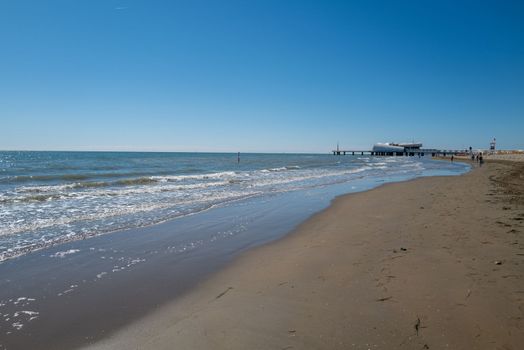 Walk on the sandy beach without people of an Italian seaside resort usually crowded with bathers in autumn.