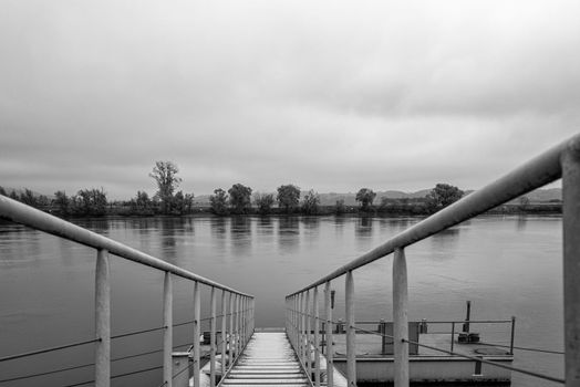 A pier at the river bank in fog.