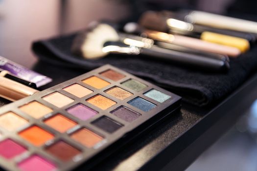 color palette and brushes in the workplace of a professional makeup artist, concept of beauty salon and skin care
