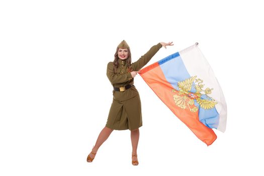 Full body of positive female model with long wavy hair in military uniform and hat smiling brightly and looking at camera while demonstrating Russian flag against white background