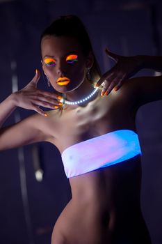 Beauty woman dance with glow make-up under ultraviolet light