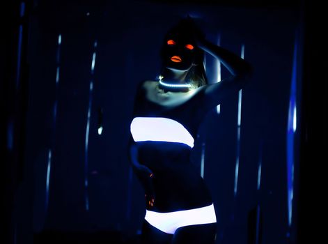 UV-light and special glow make-up on girl dance in dark