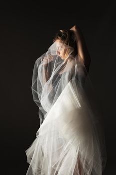 ballerina with a white dress and black top posing on gray background