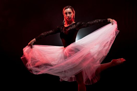 ballerina with a white dress and black top posing on red smoke background.