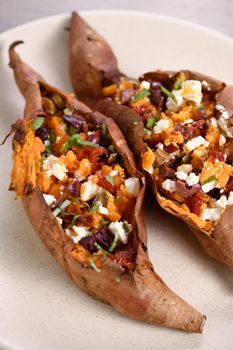 Baked sweet potato stuffed with chopped sun-dried tomatoes, olives, feta cheese and basil with aromatic dressing