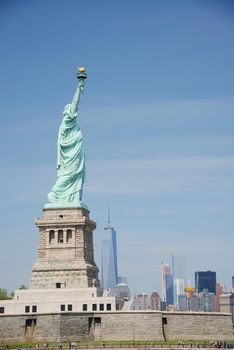 Liberty Statue with buildings in manhattan downtown new york as a background