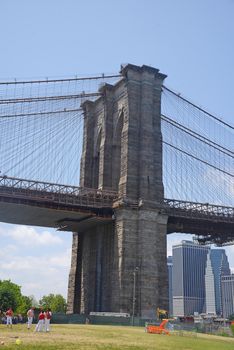 brooklyn bridge under a blue sky with downtown new york city as a background