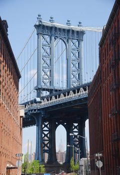 east tower of manhattan bridge framed with old building in brooklyn