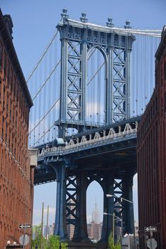 east tower of manhattan bridge framed with old building in brooklyn