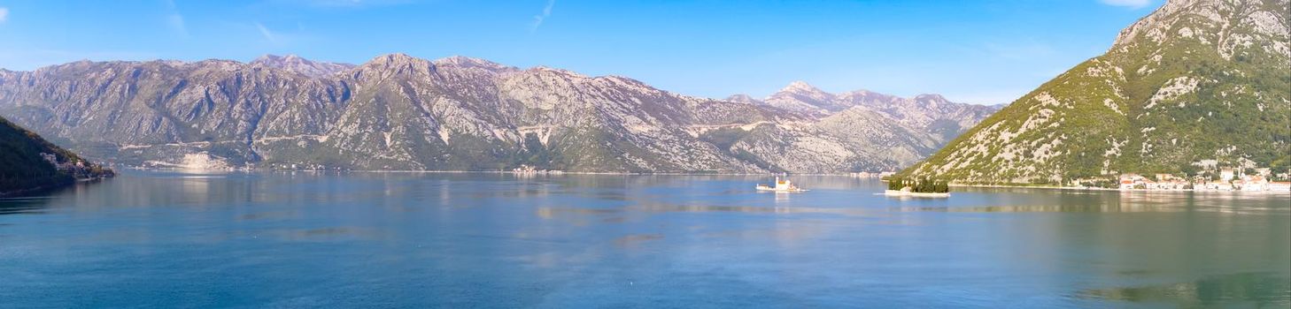 Panoramic view of Kotor bay surrounded by mountains with the city of Perast and the island of Our Lady of the rocks