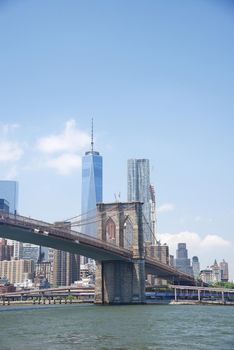 brooklyn bridge under a blue sky with downtown new york city as a background