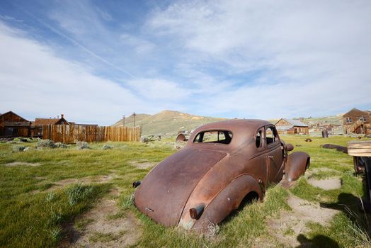 an old car in Bodie historic state park of a ghost town from a gold rush era in Sierra Nevada