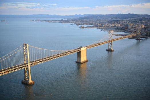 an aerial view of bay bridge near san francisco downtown during sunset, taken from a helicopter 