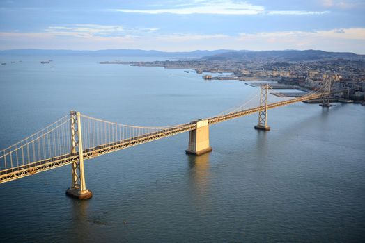 an aerial view of bay bridge near san francisco downtown during sunset, taken from a helicopter 