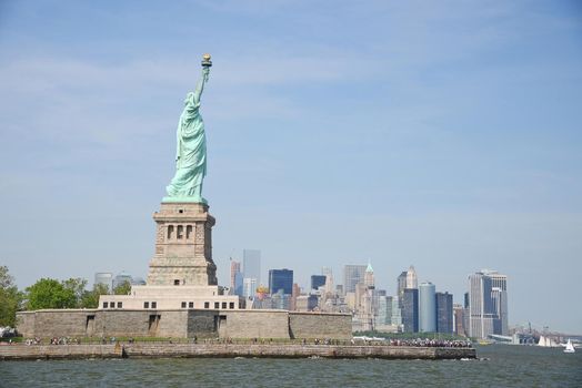 Liberty Statue with buildings in manhattan downtown new york as a background