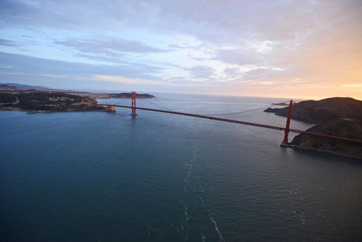 an aerial view of golden gate bridge in san francisco during sunset, taken from a helicopter