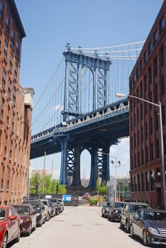 east tower of manhattan bridge framed with old building in brooklyn