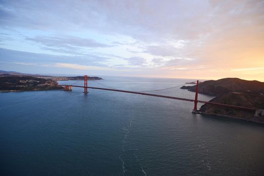 an aerial view of golden gate bridge in san francisco during sunset, taken from a helicopter