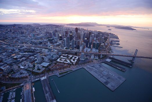 an aerial view of bay bridge near san francisco downtown during sunset, taken from a helicopter 