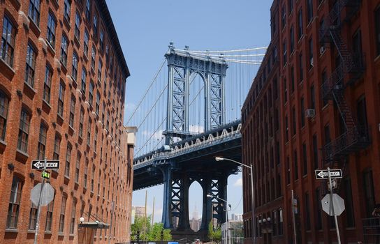 east tower of manhattan bridge framed with old building in brooklyn