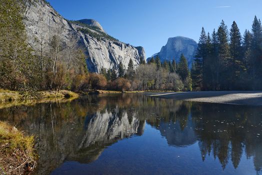 a reflection of half dome of yosemite over merced river