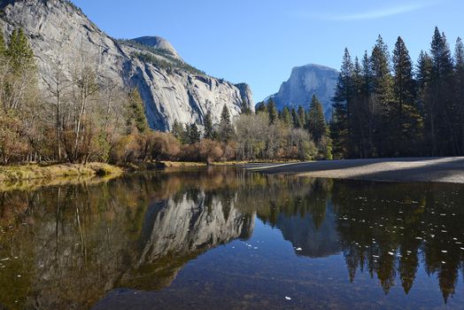 a reflection of half dome of yosemite over merced river