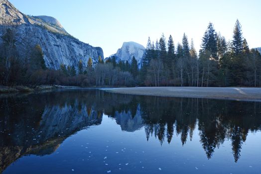 a reflection of half dome of yosemite over merced river