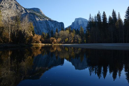 a reflection of half dome of yosemite over merced river