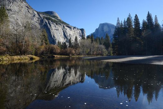 a reflection of half dome of yosemite over merced river