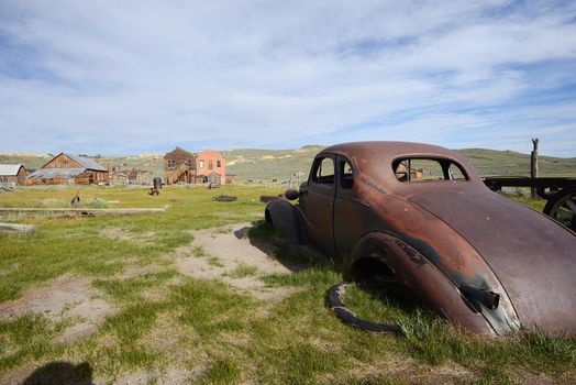 an old car in Bodie historic state park of a ghost town from a gold rush era in Sierra Nevada