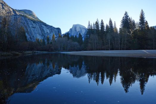 a reflection of half dome of yosemite over merced river