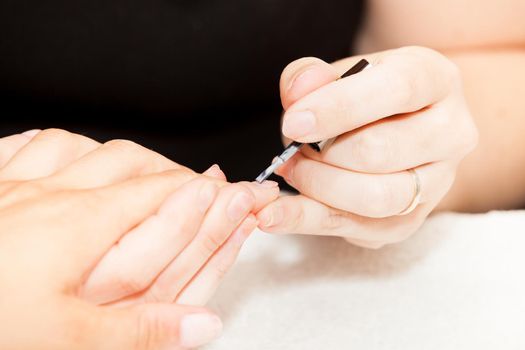 Laying nail polish on a woman's hands