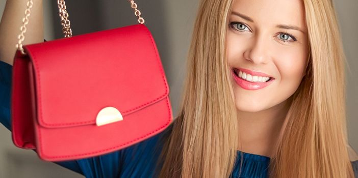 Fashion and accessories, happy beautiful woman holding small red handbag with golden details as stylish accessory and luxury shopping concept