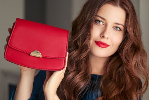 Fashion and accessories, happy beautiful woman holding small red handbag with golden details as stylish accessory and luxury shopping concept