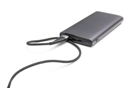 Fully charged portable powerbank with cable and two usb outputs isolated on a white background. Powerbank for charging mobile devices.